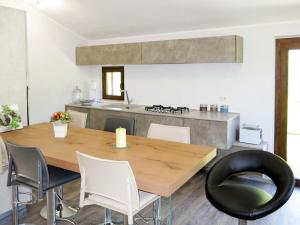 een eetkamer met een houten tafel en stoelen bij Apartment Serrani-3 by Interhome in Cologna