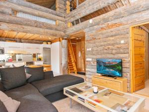 een woonkamer met een bank en een tv bij Holiday Home Peikkola by Interhome in Ruka