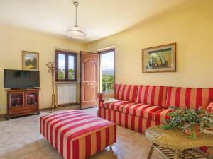 salon z czerwoną kanapą i telewizorem w obiekcie Apartment Ca` del Lovi-3 by Interhome w mieście Chiatri