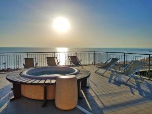 a deck with chairs and a fire pit on the beach at Apartment Casa del Mar-2 by Interhome in Roseto degli Abruzzi