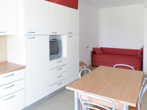 a kitchen with a table and a red couch at Apartment Casa del Mar-2 by Interhome in Roseto degli Abruzzi