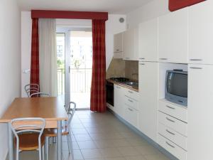 a kitchen with white cabinets and a table with chairs at Apartment Casa del Mar-2 by Interhome in Roseto degli Abruzzi