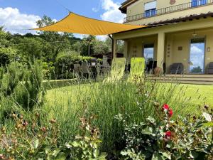a garden with tall grass and flowers in front of a house at Holiday Home Pianelli by Interhome in Pergine Valdarno