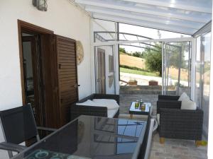 d'une terrasse avec une table, des chaises et une porte en verre. dans l'établissement Apartment Serrani-2 by Interhome, à Cologna