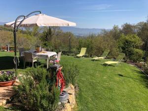 un giardino con tavolo, sedie e ombrellone di Holiday Home Pianelli by Interhome a Pergine Valdarno
