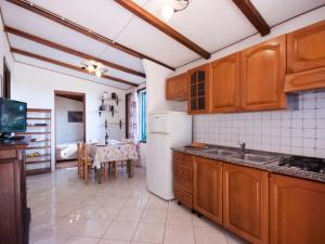 a kitchen with wooden cabinets and a dining room at Holiday Home Piccola Oasi 4 by Interhome in Capoliveri