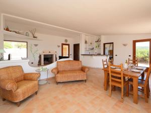 a living room with a table and chairs and a kitchen at Holiday Home Alba by Interhome in Greuli 