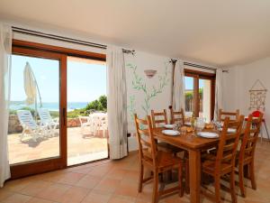 a dining room with a table and chairs and a balcony at Holiday Home Alba by Interhome in Greuli 
