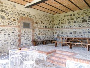 a room with stone walls and tables and chairs at Apartment Il Podere del Lago - BOL253 by Interhome in Bolsena
