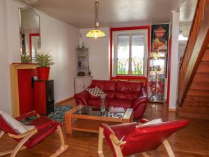 salon z czerwoną skórzaną kanapą i krzesłami w obiekcie Holiday Home L'Oté rouge - PLX105 by Interhome w mieście Plérin