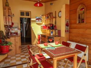 kuchnia ze stołem i krzesłami w pokoju w obiekcie Holiday Home L'Oté rouge - PLX105 by Interhome w mieście Plérin