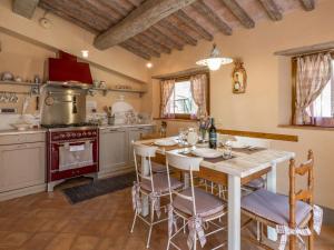 kuchnia ze stołem, krzesłami i kuchenką w obiekcie Holiday Home La Casetta by Interhome w mieście Sassofortino