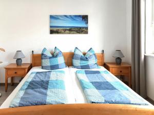 - une chambre avec 2 lits dotés d'oreillers bleus et blancs dans l'établissement Apartment Juliusruh-5 by Interhome, à Juliusruh