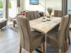 a dining room with a wooden table and chairs at Apartment Juliusruh-5 by Interhome in Juliusruh