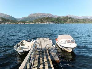 two boats are docked at a dock on a lake at Holiday Home Rabbane - FJS504 by Interhome in Nyttingsnes