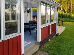 a red and white house with a porch at Chalet Höje - VMD220 by Interhome in Hagfors