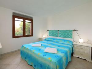 ein Schlafzimmer mit einem blauen Bett und einem Fenster in der Unterkunft Holiday Home Tritone by Interhome in Costa Corallina