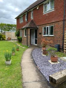 a brick house with a gravel path in front of it at West Lodge B&B in Hailsham