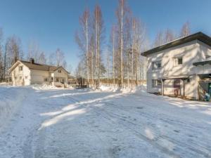 a snow covered road in front of a house at Holiday Home Halmesaari by Interhome in Kerkonjoensuu