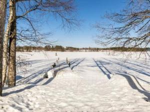 a snow covered field with trees and a road at Holiday Home Halmesaari by Interhome in Kerkonjoensuu
