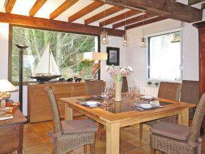 una sala da pranzo con tavolo in legno e barca a vela di Holiday Home Etoile de Mer - EQY101 by Interhome a Erquy