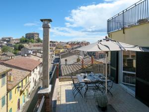 a balcony with a table and an umbrella at Holiday Home Mimmina by Interhome in Capodimonte