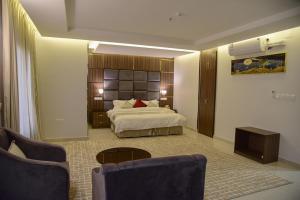 巴勒如拉斯غيوم للفلل الفندقية的一间带床、桌椅的酒店房间