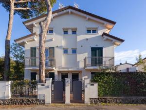 biały dom z płotem i drzewami w obiekcie Apartment Michelangelo II by Interhome w mieście Marina di Pietrasanta