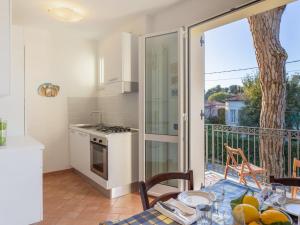 a kitchen with a table and a balcony with a tree at Apartment Michelangelo II by Interhome in Marina di Pietrasanta