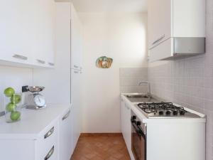 Biała kuchnia z kuchenką i białymi szafkami w obiekcie Apartment Michelangelo II by Interhome w mieście Marina di Pietrasanta +16 zdjęć