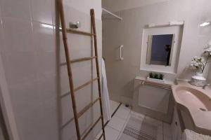 un baño con una escalera junto a un lavabo y un espejo en Maison de village 60m2 pratique et confortable, en Lapalme