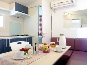 a table with cups and bowls of fruit on it at Holiday Home Residence Village-1 by Interhome in Cavallino-Treporti