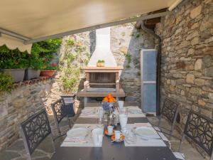 a table and chairs on a patio with a fireplace at Holiday Home Gabriella by Interhome in Domaso