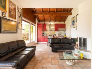 a living room with leather couches and a kitchen at Holiday Home Gabriella by Interhome in Domaso