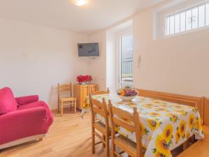 a living room with a table and a red couch at Apartment Glicine by Interhome in Perledo