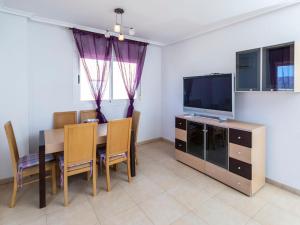 a dining room with a table and a television at Apartment Frontal Montañas by Interhome in Oropesa del Mar