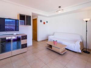 a living room with a couch and a flat screen tv at Apartment Frontal Montañas by Interhome in Oropesa del Mar