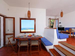 una sala da pranzo con tavolo e divano blu di Holiday Home La Cala - VGM615 by Interhome a Aglientu