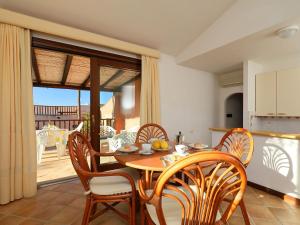 a kitchen and dining room with a table and chairs at Holiday Home Erica 22 - Vista Village by Interhome in Porto San Paolo