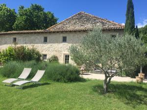 two white chairs sitting in the grass in front of a building at Maison de Charme dans Domaine 17ème in Tarascon
