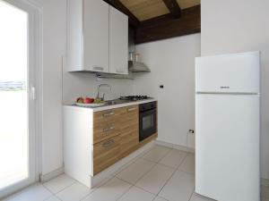 a kitchen with white cabinets and a refrigerator at Apartment Rosburgo-4 by Interhome in Roseto degli Abruzzi