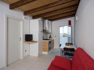 a living room with a red couch and a kitchen at Apartment Rosburgo-4 by Interhome in Roseto degli Abruzzi