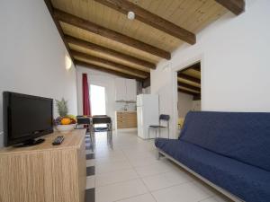 a living room with a bed and a tv and a kitchen at Apartment Rosburgo-4 by Interhome in Roseto degli Abruzzi