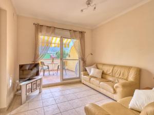 a living room with a couch and a television at Apartment Alqueria Sol by Interhome in Denia