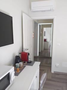 eine weiße Küche mit einem Tisch und einem TV an der Wand in der Unterkunft Nel cuore del Centro Storico in Turin