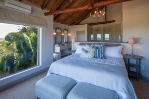 a bedroom with a large bed and a large window at Fort D'Acre in Port Alfred