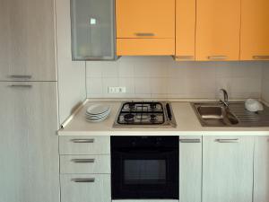 a kitchen with white cabinets and a stove top oven at Apartment Vistamare by Interhome in San Silvestro