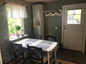 een keuken met een tafel en stoelen en een raam bij Stuga på Öland in Algutsrum +9 foto's