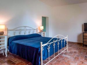 una camera da letto con un letto con una coperta blu di Holiday Home Podere Sant' Antonio-4 by Interhome a Bolsena Altre 24 foto