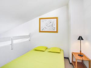 サン・シプリアン・プラージュにあるStudio Les Goelettes-15 by Interhomeの緑のベッドと壁の絵が備わるベッドルーム1室が備わります。